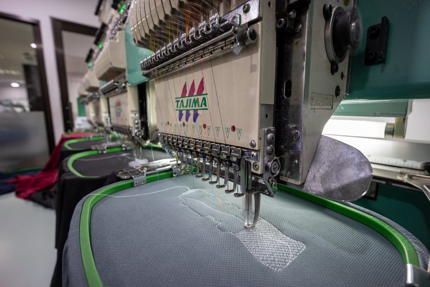 Multi-head embroidery machine stitching a design